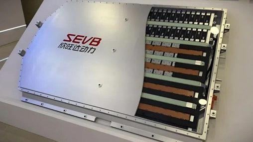 Open battery module with SEVB branding showing rows of prismatic cells and copper busbars on a display stand