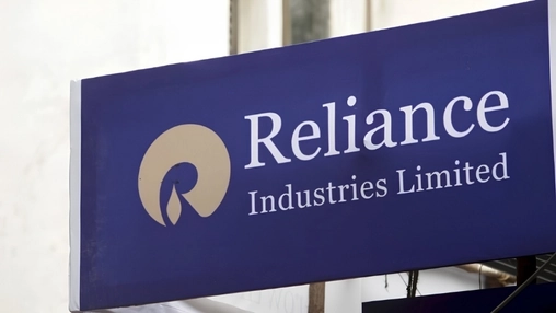 Close-up of the Reliance Industries Limited sign with company name and gold circular logo on a blue background